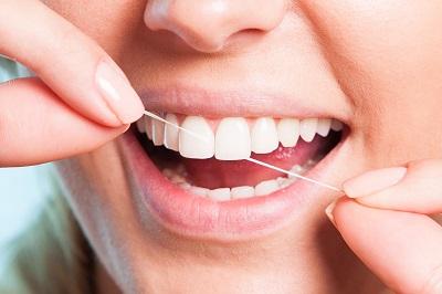 Woman flossing her teeth after learning about Preventative Dentistry from Smile Ninja Dental in Fort Worth, Texas