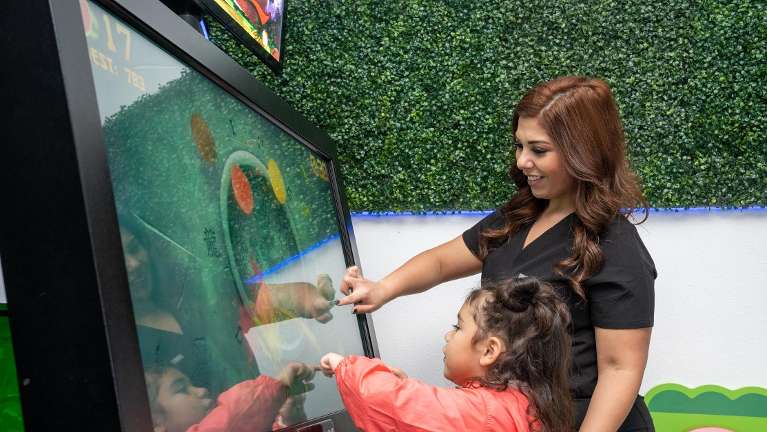 Little Girl playing before her exam with a pediatric sedation dentist in Fort Worth, Texas