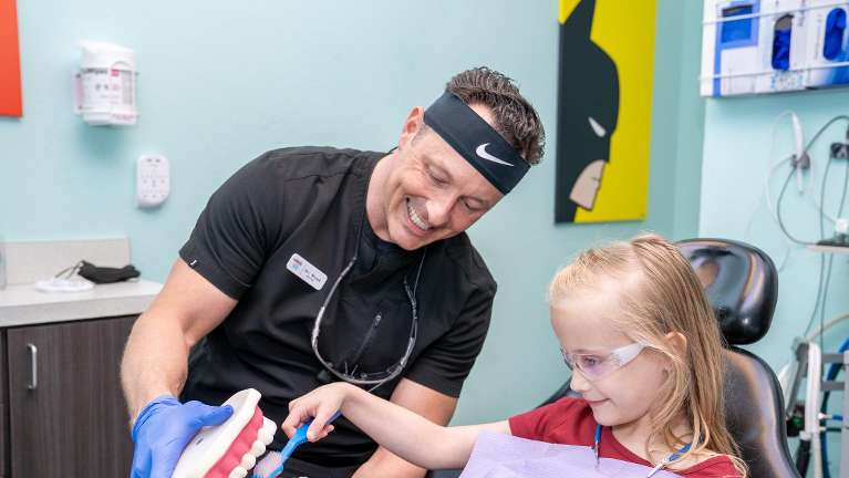 A child learning about dental hygiene before her sedation dentistry appointment in Fort Worth, Texas