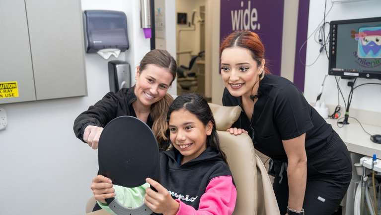 A young girl, happy after visiting her childrens dentist near Aledo, TX